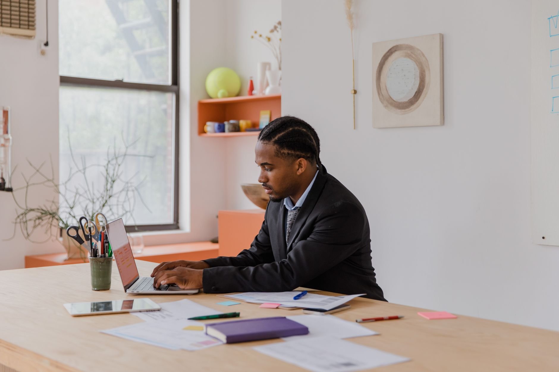 Professional business owner working at a laptop in a warm, well-lit office