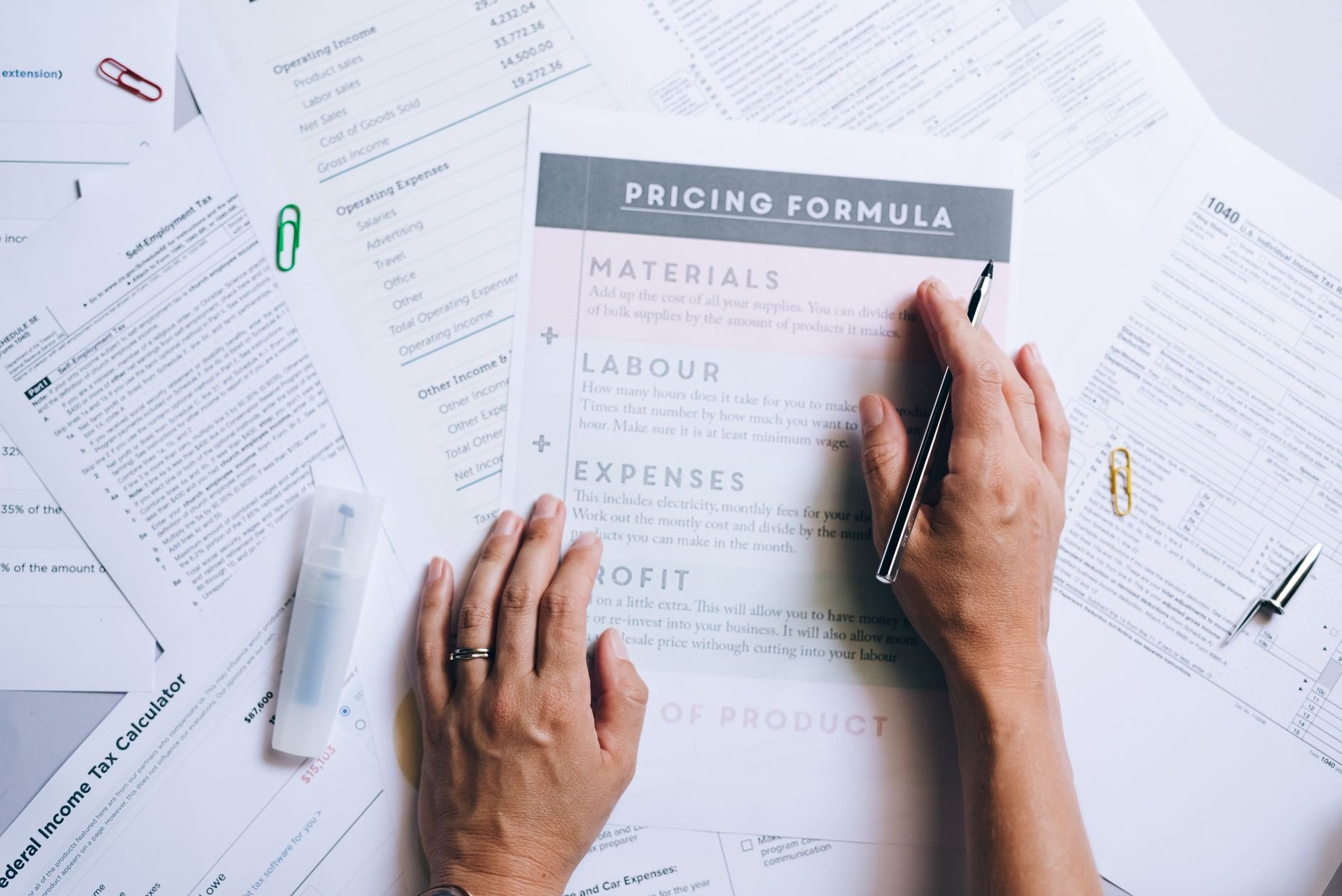 Business documents with pricing formulas organized on an office desk